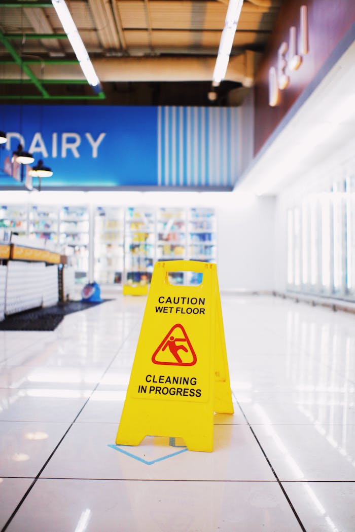 journey Yellow plastic warning sing with inscription Wet floor placed in empty store in modern mall